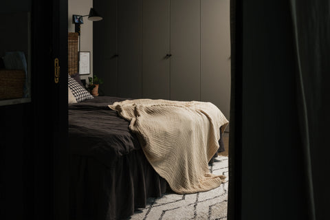 Stora Sand draperad över fotänden på en säng